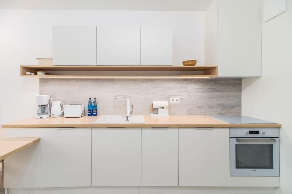 A close-up of the kitchen's open shelving, white cabinetry, and modern appliances.
