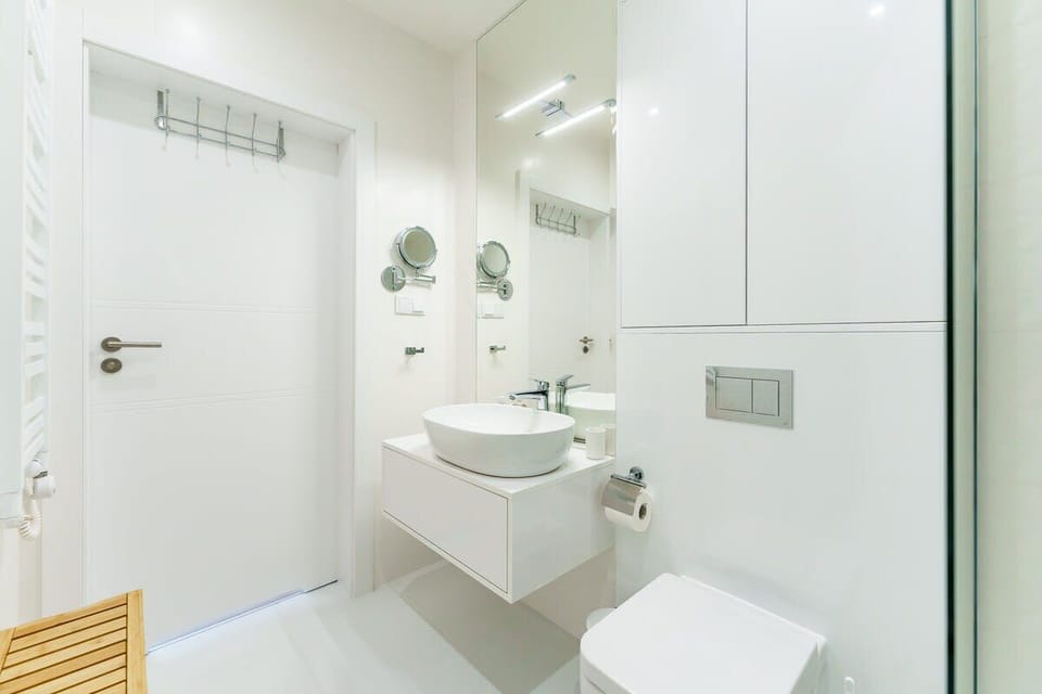 The bathroom's contemporary design includes fresh towels and a hairdryer. 