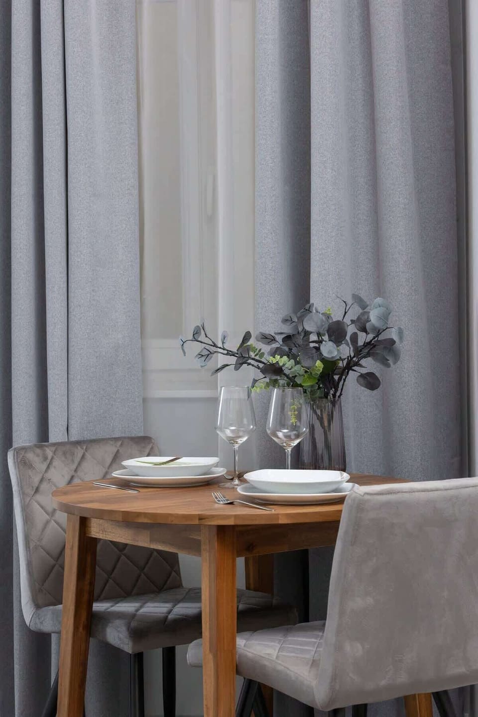 A closer detail of the same table, focusing on the floral centerpiece and subtle grey seating.

