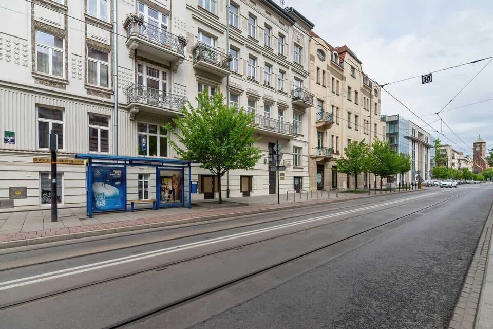 Another view of the exterior, revealing the building’s classic style and a tram track running alongside.






