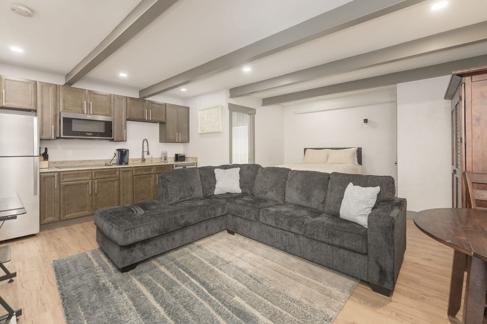 Mother in Law suite with upgraded full size bed, sectional sleeper sofa, small kitchen, full bathroom, and TV.
