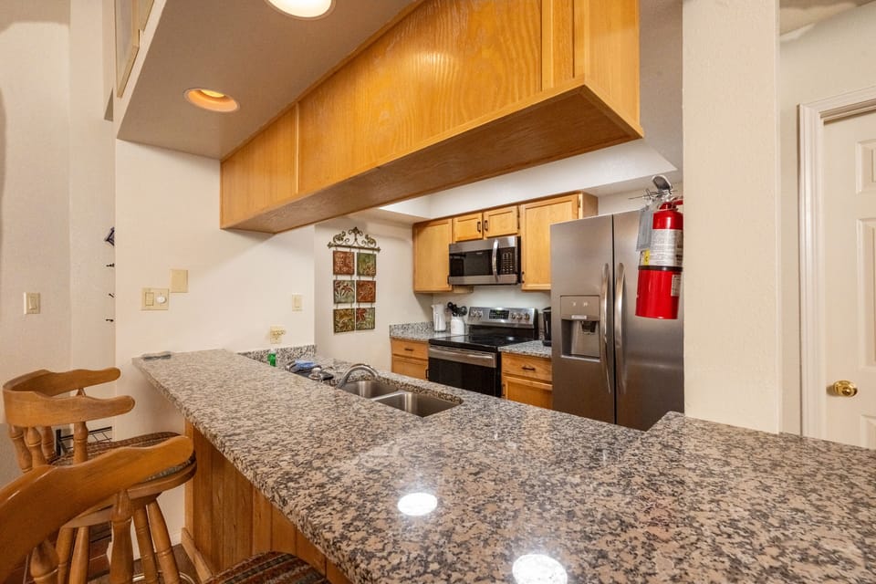 Granite countertops with Stainless Steep Appliances & breakfast bar.