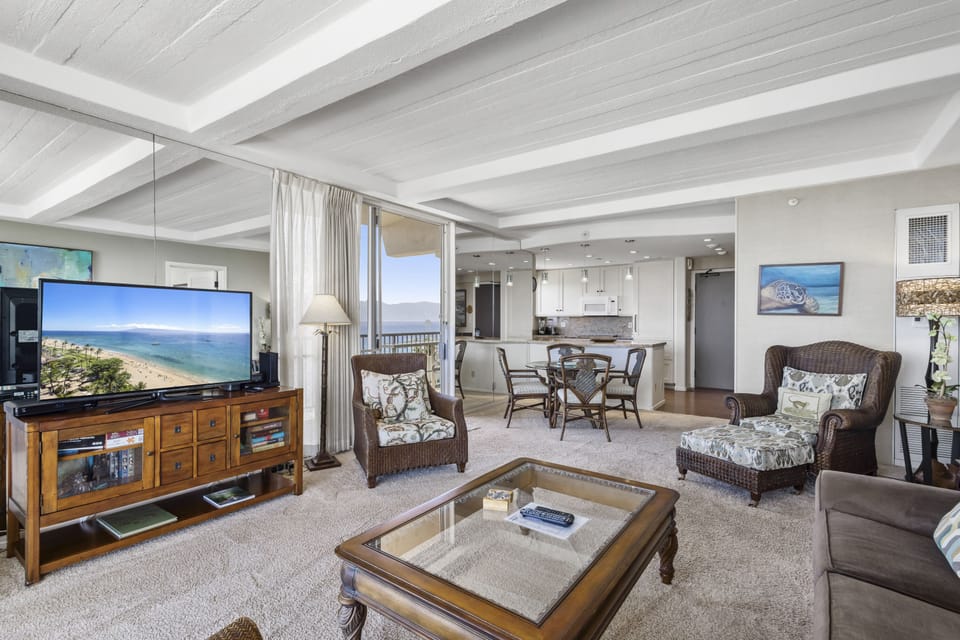 Imagine yourself relaxing in this open, coastal-inspired living space with stunning ocean views just beyond the balcony. Your beachside retreat features comfortable seating, modern kitchen amenities, and nautical décor.
