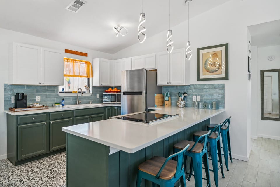 Fully Stocked Kitchen with Stainless Steel Appliances and Bar Seating