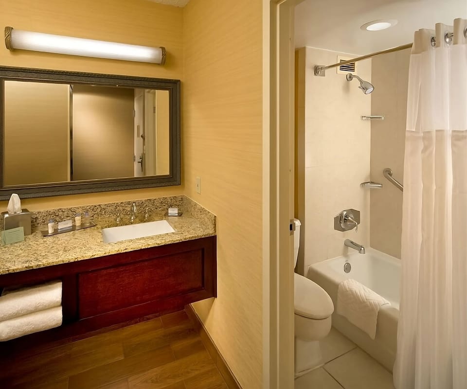 Refresh under a hot shower beside a bright vanity.