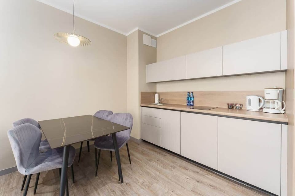 A dining area with a modern table, chairs, and a pendant light, designed for comfort and style.
