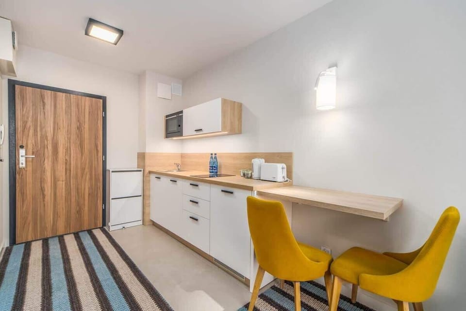 Kitchenette with kettle and refrigerator. 