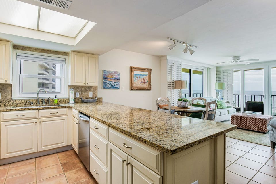 Kitchen counter and workspace at Lei Lani 401 — granite countertops and an open layout connecting directly to the living area of this Orange Beach condo.