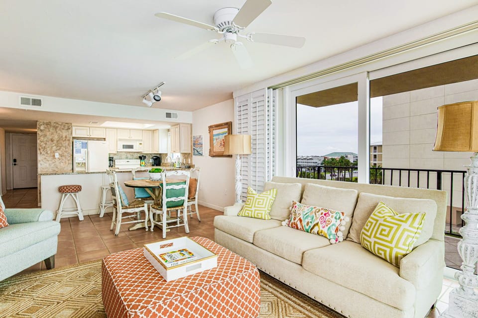 Open-concept living, dining, and kitchen area at Lei Lani 401 — tile flooring, natural light, and seamless flow throughout this Orange Beach corner unit.