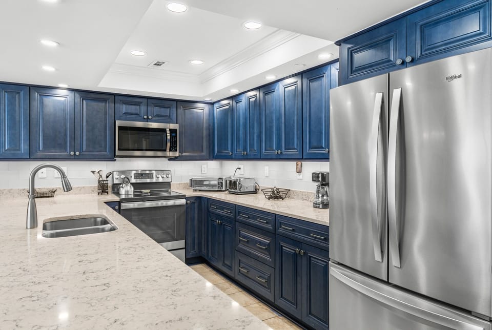 Your stunning kitchen features elegant navy cabinetry, gleaming granite countertops, and premium stainless steel appliances perfect for memorable meals.