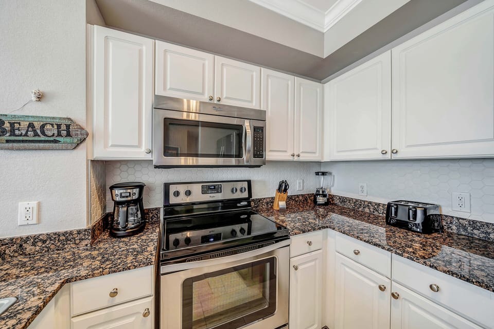The fully equipped kitchen features granite countertops and stainless-steel appliances.