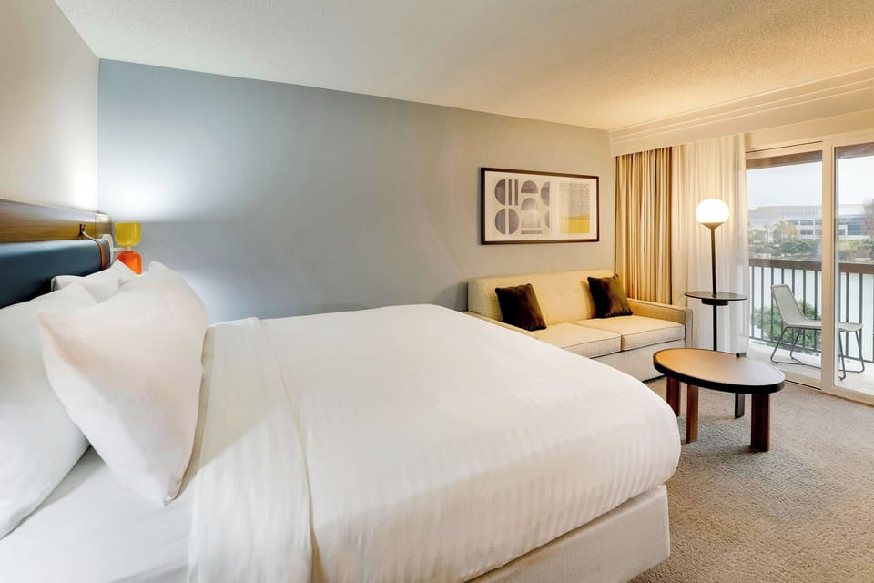 Unwind in a plush king bed beside a sunny balcony.