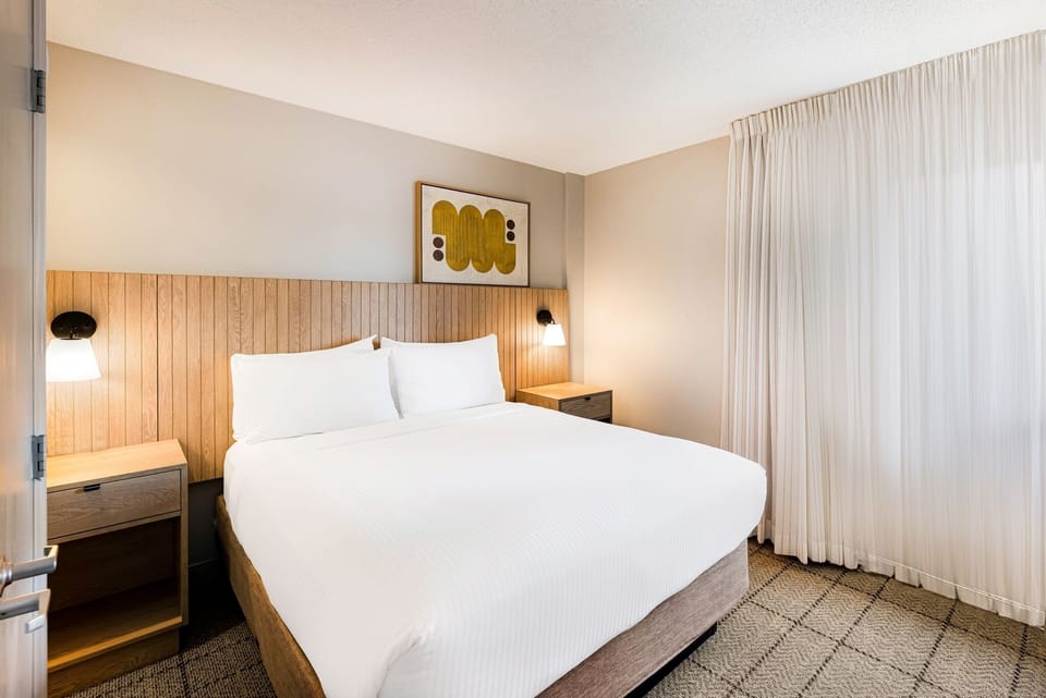 Sink into a serene bedroom with warm lighting and space.