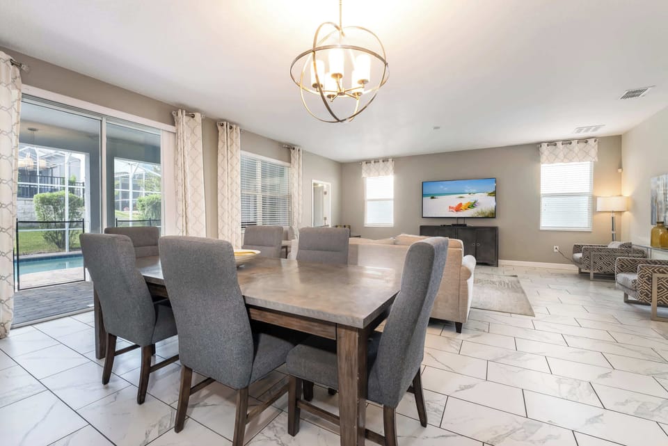 Spacious living and dining area with pool view, perfect for entertaining and relaxation.