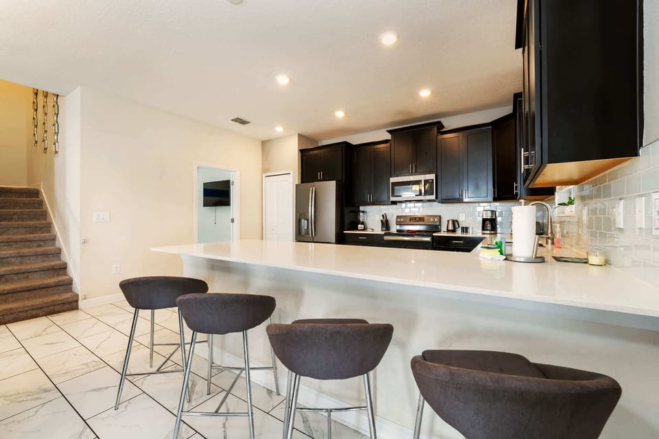 Spacious modern kitchen with sleek appliances and ample seating, perfect for entertaining.