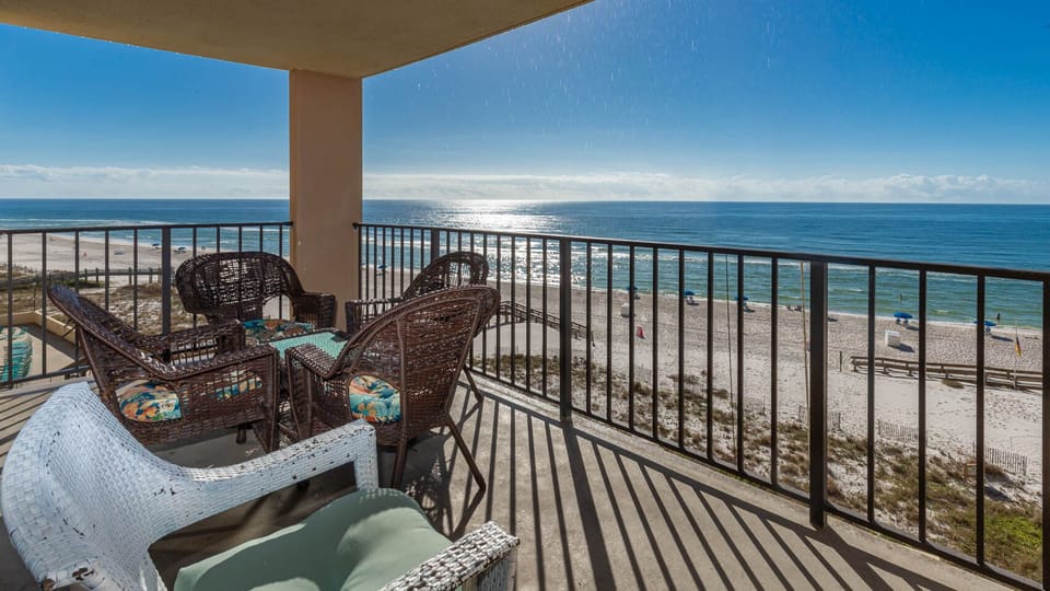 Relax on the balcony with comfortable wicker seating and enjoy breathtaking views of the sandy beach and sparkling waters