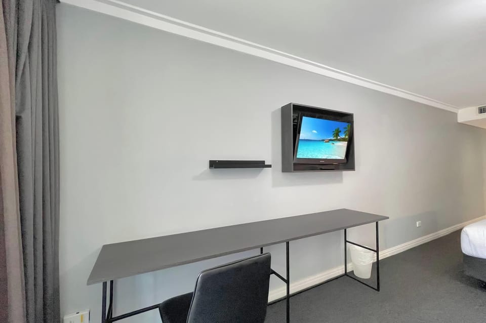 Working station with long desk and wall-mounted TV.