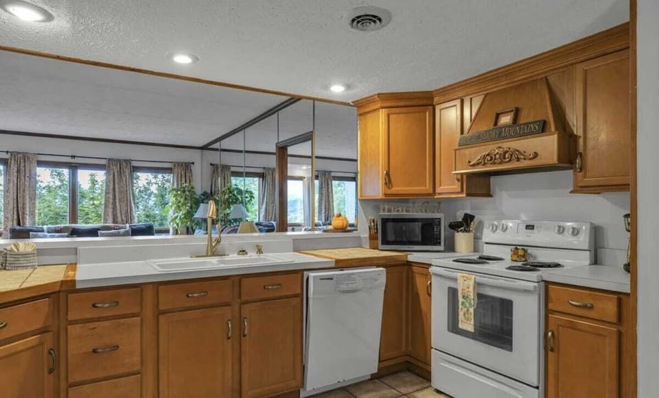 Kitchen: Brightly lit with mountain views, perfect for culinary adventures and gathering with friends!