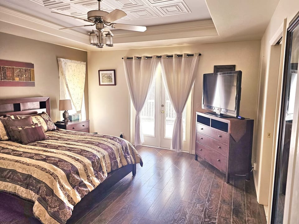Master bedroom with queen bed, ensuite bath, ceiling fan, and walk-in closet.