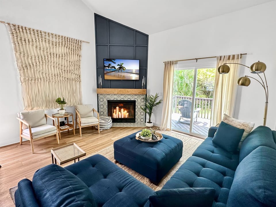 Our bright and beautifully decorated living room which features a: Comfortable L shaped sofa, Smart TV w/ Cable & Streaming Apps. And a direct access to the back porch, bordering Gulf State Park.
