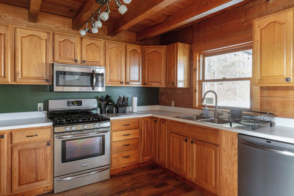 Rustic wood kitchen with stainless appliances and bright window views