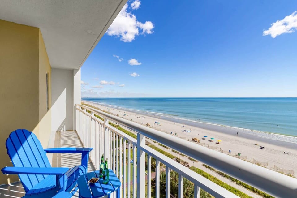 Enjoy a slice of paradise from this stunning beachfront balcony. Relax in vibrant Adirondack chairs, sipping your favorite drink while overlooking miles of pristine sands and sparkling waters. It's the perfect spot for unforgettable seaside moments.