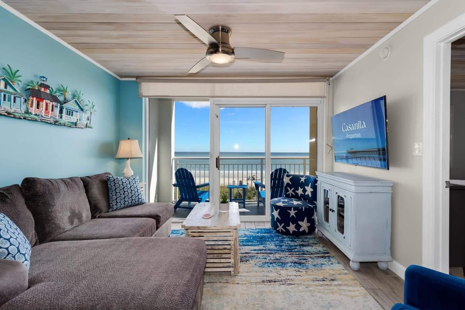 Unwind in this coastal-inspired living room with cozy seating, charming decor, and floor-to-ceiling views of the ocean. Step onto the balcony to feel the sea breeze or relax indoors with all the comforts of a stylish beachside retreat.