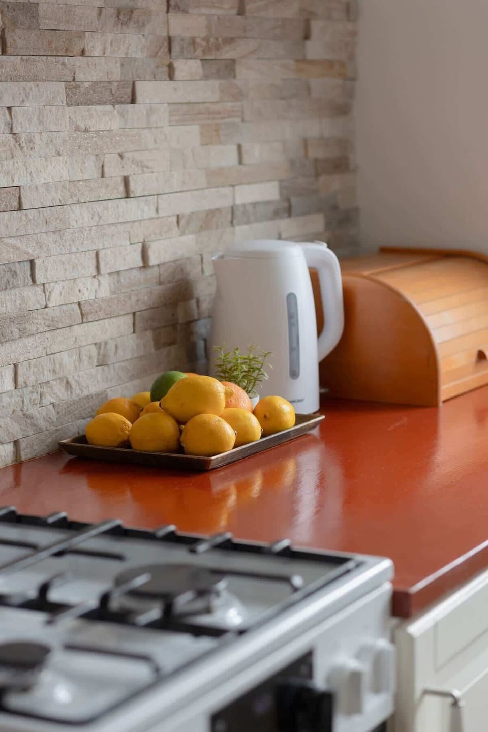 A well-equipped kitchen featuring a built-in oven, microwave, and a brick-style backsplash.

