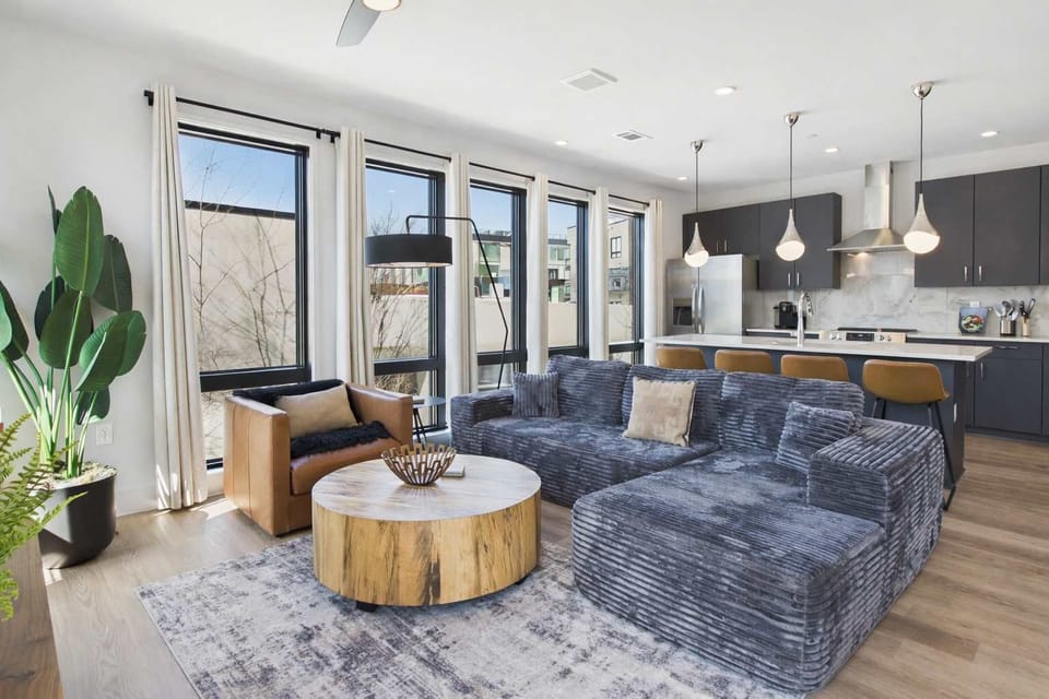 Bright living room with comfortable seating, smart TV, designer decor, and access to the private patio.