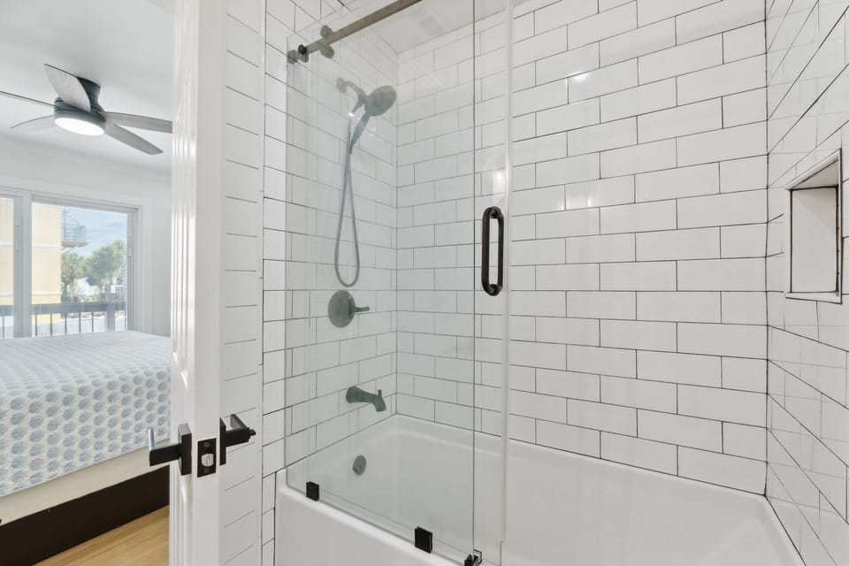 Modern bathroom with a glass-enclosed shower and white subway tile.