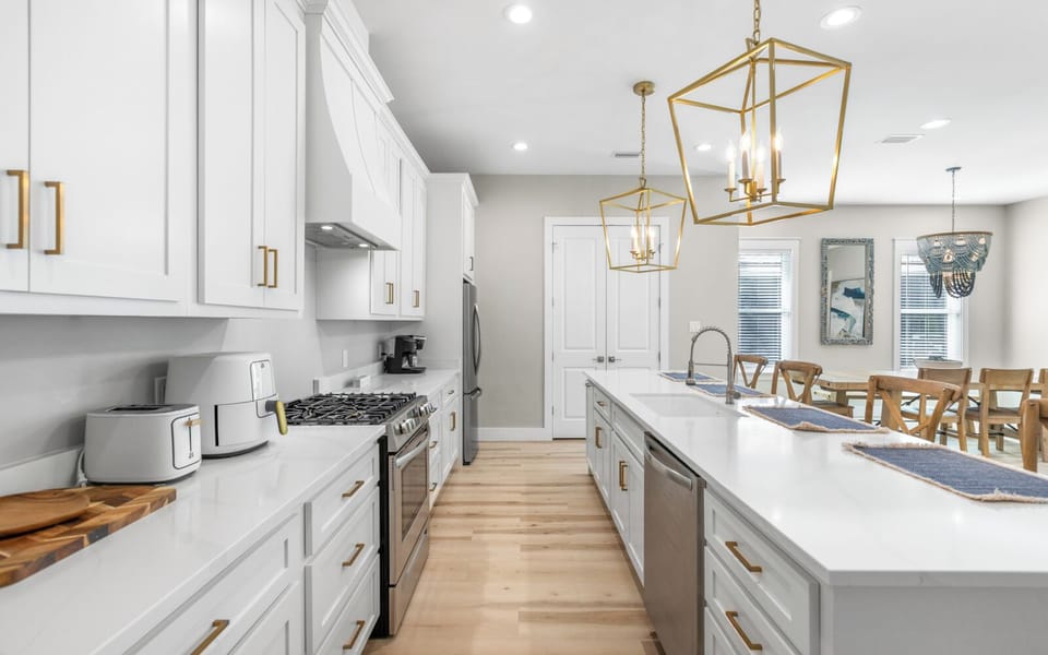 Cook memorable meals in your spacious modern kitchen with stainless steel appliances and elegant gold pendant lighting.