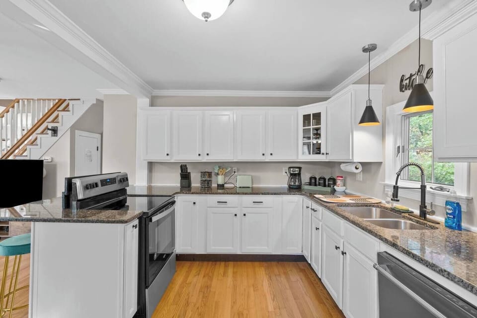 Our kitchen features granite countertops, white cabinets with black pulls, black & gold fixtures, and stainless steel appliances. 