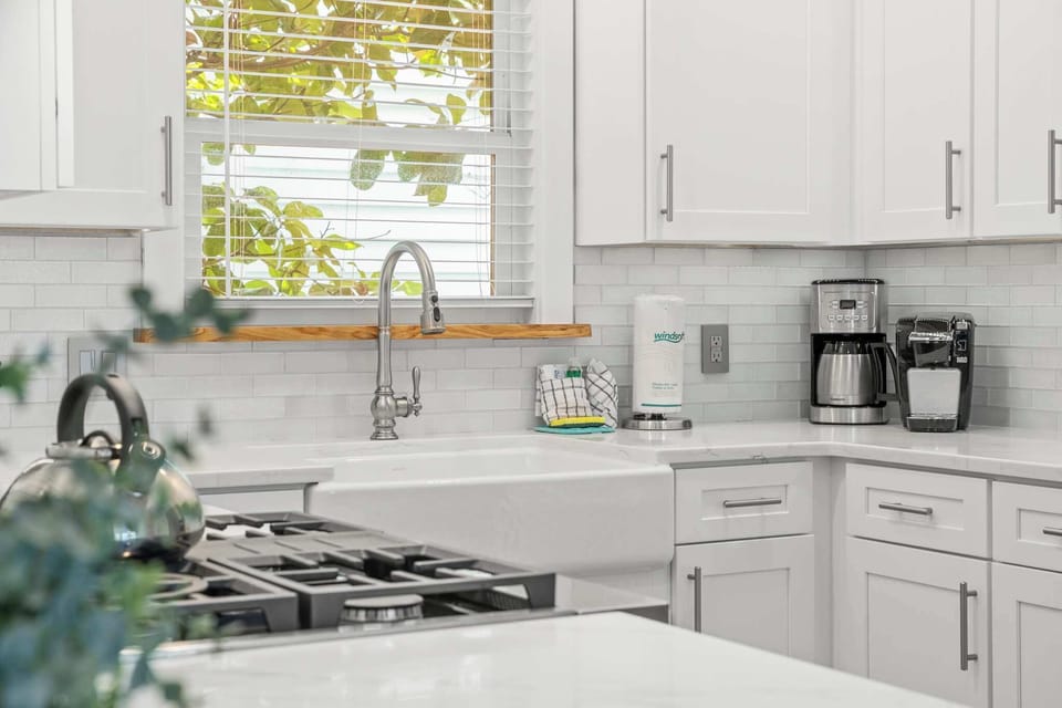 White shaker cabinets, sleek white subway tile, and a classic farmhouse sink set the tone for timeless Southern charm.