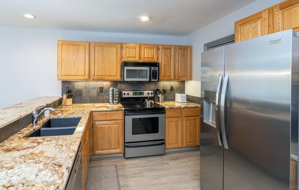 Great spacious kitchen with stainless steel appliances, electric stove and ample counter space.