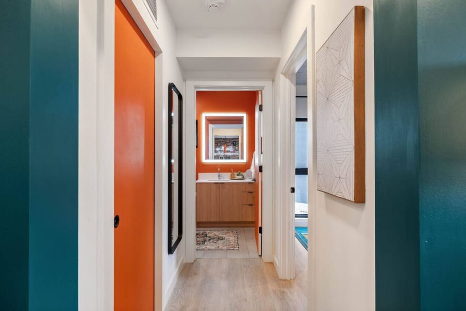 Hallway looking into bathroom from living room. Bedroom door on the right and laundry room on the left.