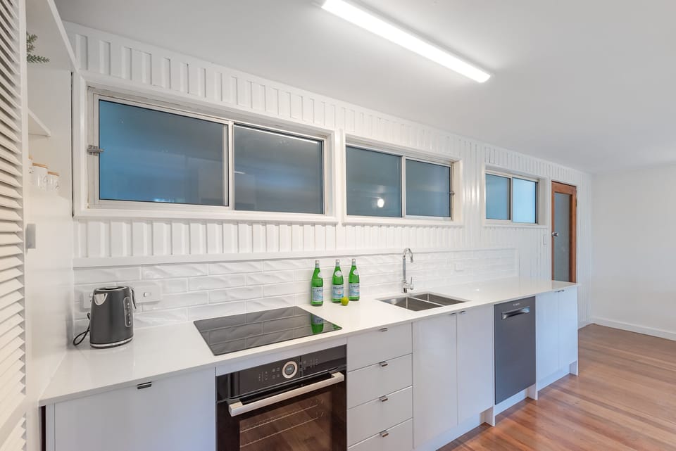 Kitchen with induction cooktop, oven, dishwasher, air fryer and Nespresso setup.