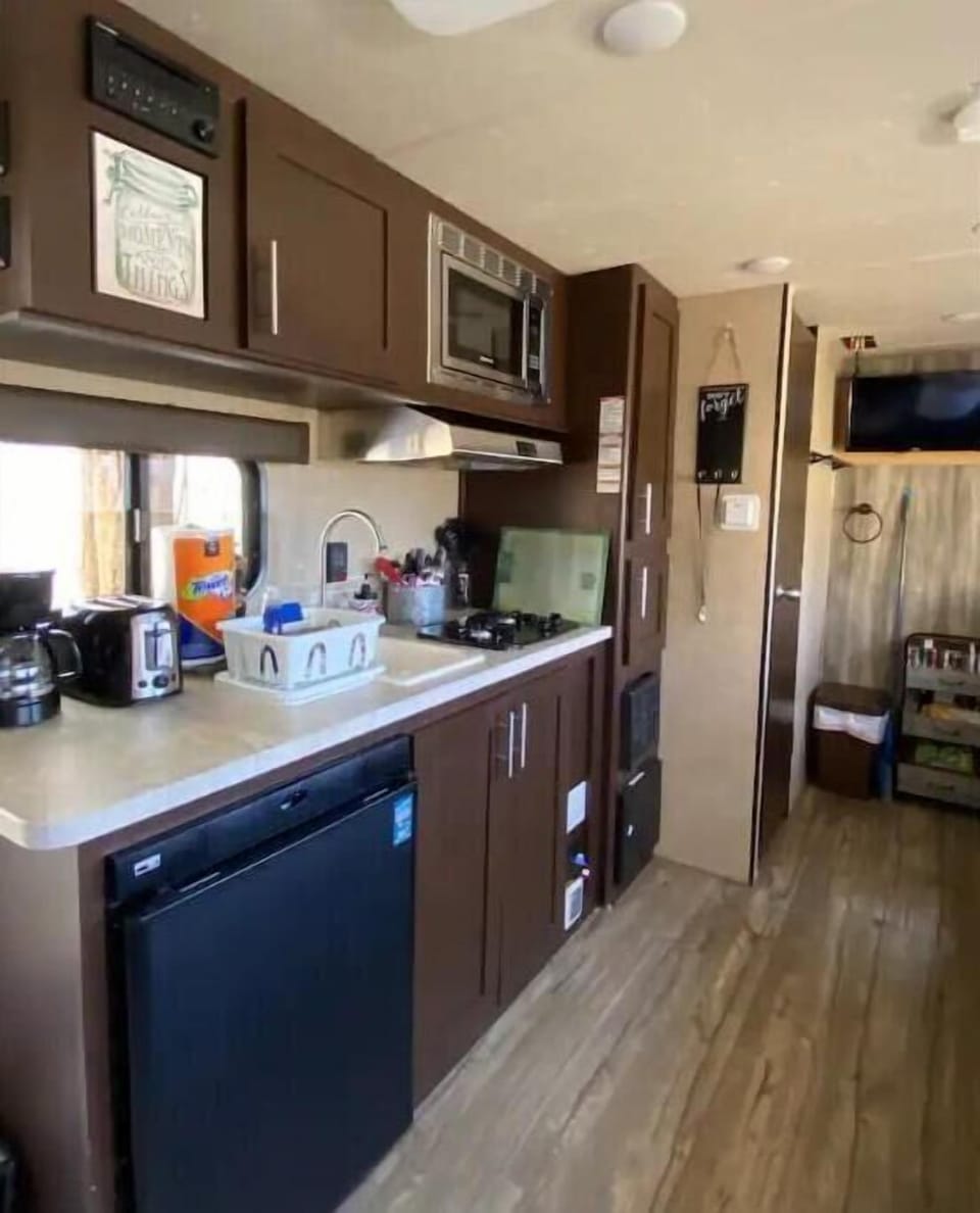 Fully stocked kitchen with coffee maker, toaster, gas stove top, microwave.