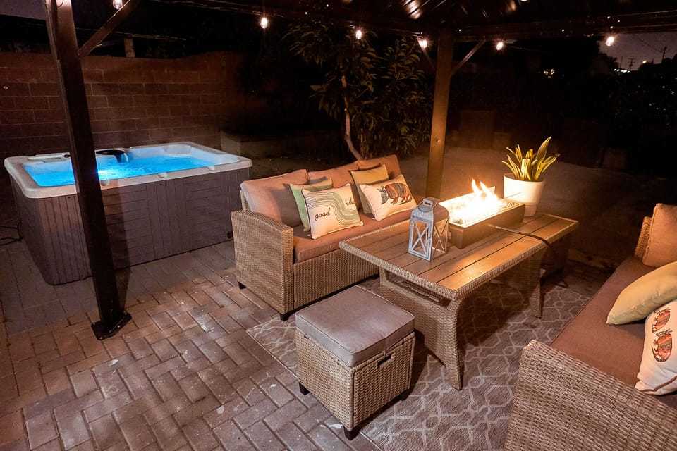 Private cozy patio with hot tub, fire pit, and decorative lights