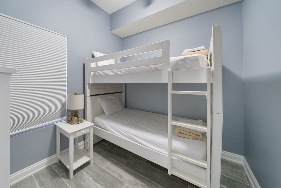 Your kids will love this cozy bunk room with crisp white linens and cheerful blue walls—perfect for sibling adventures and bedtime stories.