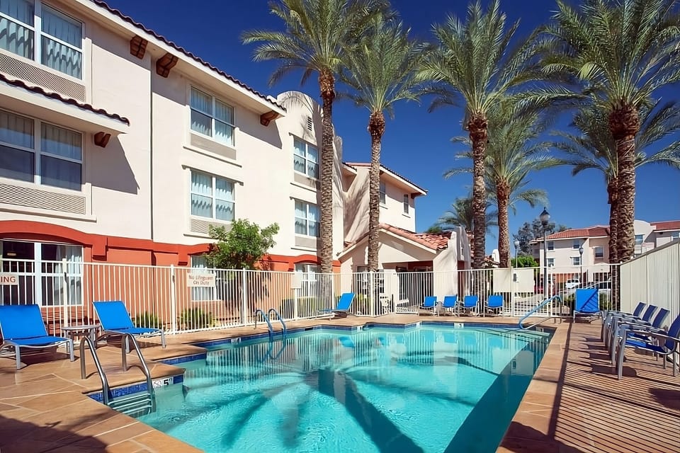 Dive into sunlit relaxation beside the sparkling palm-lined pool.