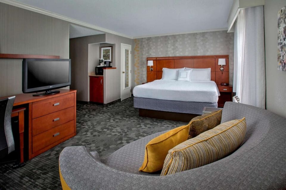 Sink into plush comfort with a cozy sofa beside the bed.