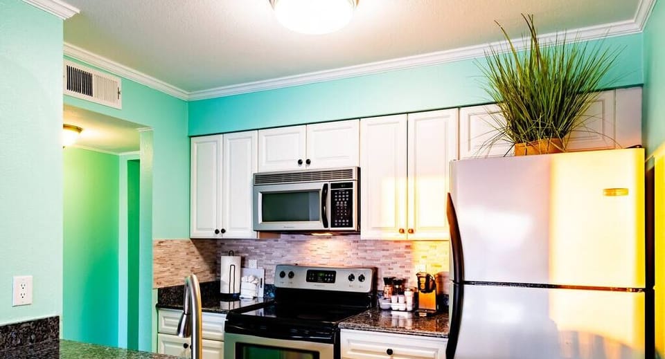 An elegant kitchen with plenty of counter space, wash basin and modern appliances.
