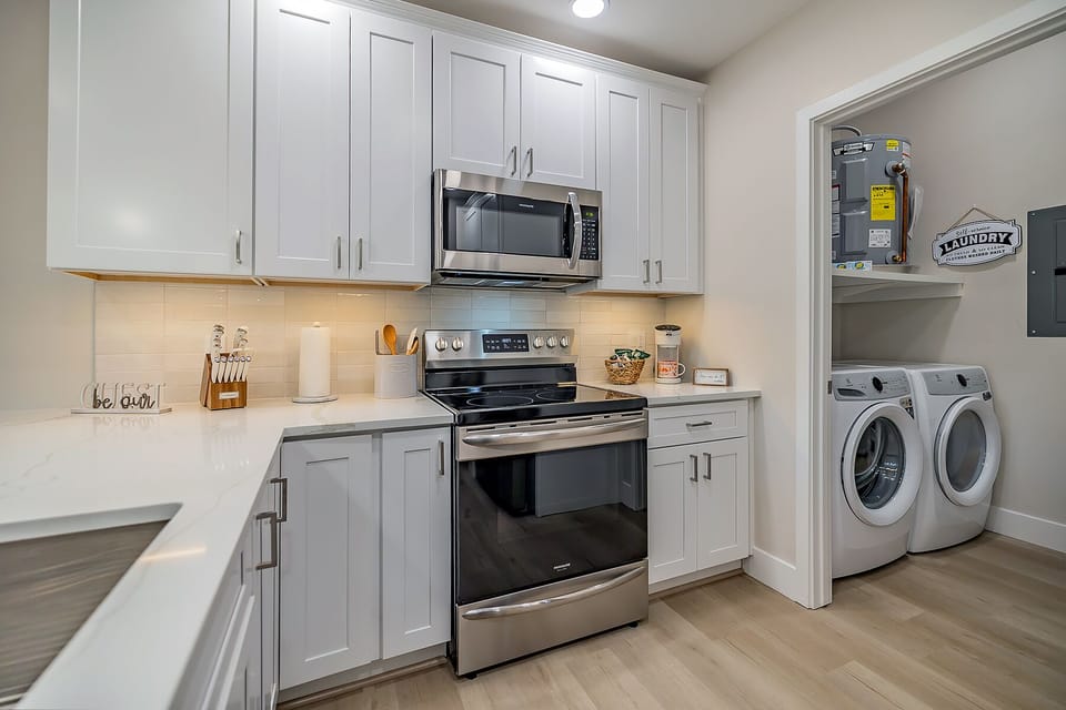 Fully equipped kitchen and laundry room featuring brand new washer and dryer, providing convenience for all your cooking and cleaning needs.