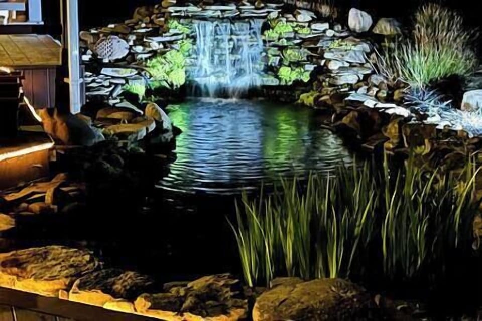 22 pond and waterfall lit up at night