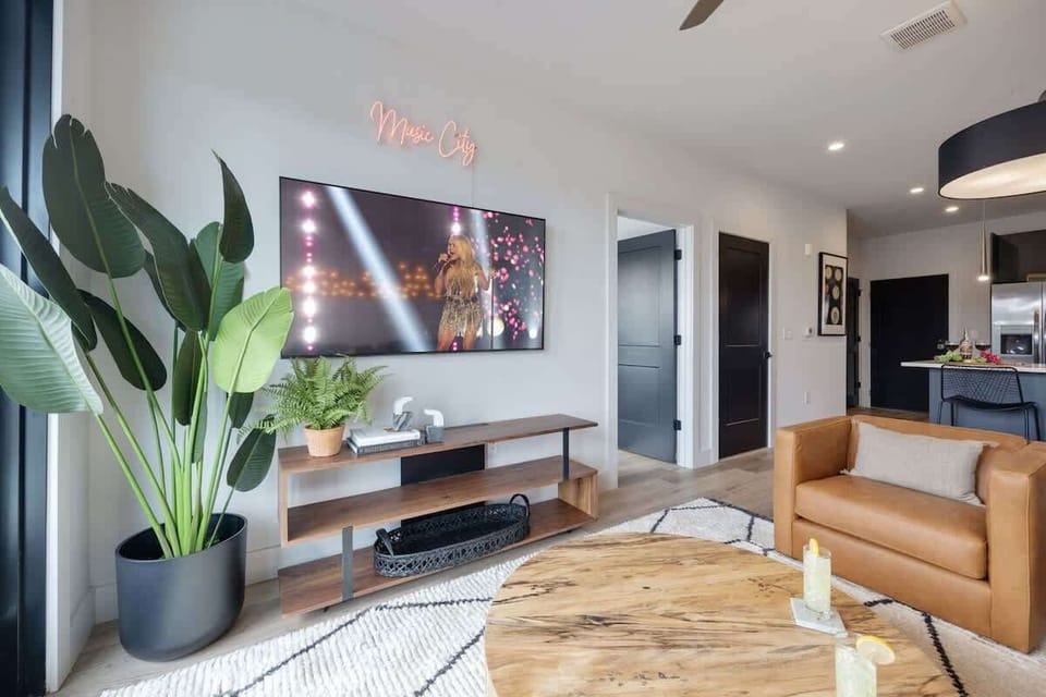 Bright living room with comfortable seating, smart TV, designer decor, and access to the private patio.