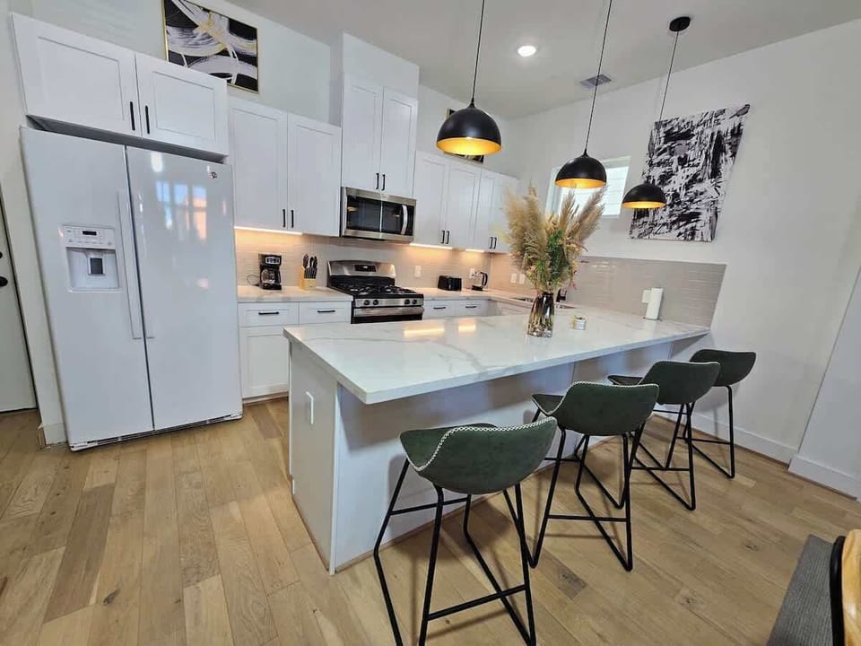 "Experience the epitome of style and sophistication in our Mid-Century gem. Stainless steel appliances, marble counters, and elegant black and gold accents define the space."