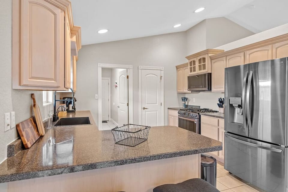 Discover culinary convenience in the well-equipped kitchen, featuring a refrigerator, microwave oven, stove, and a handy coffee maker.