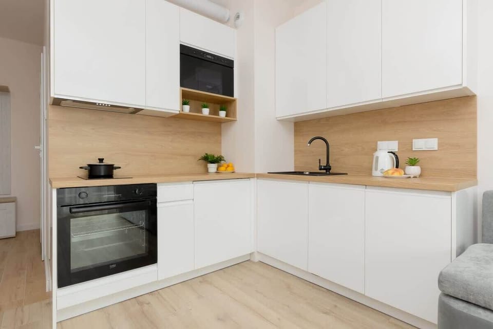 A functional kitchen featuring a built-in oven, sink, and minimalist design.
