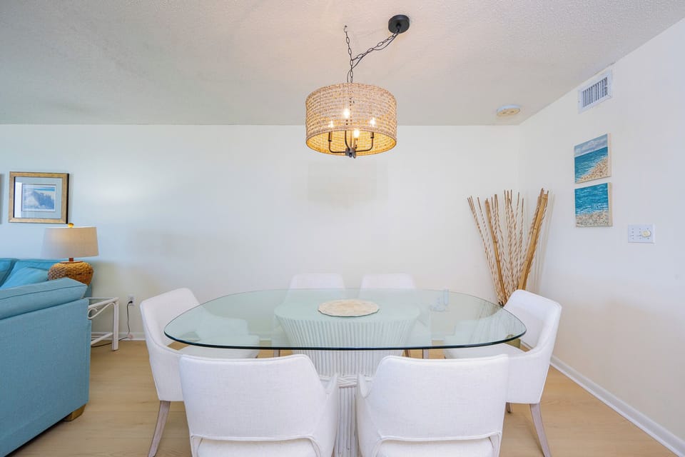 Gather around the glass dining table where laughter and shared meals create lasting memories