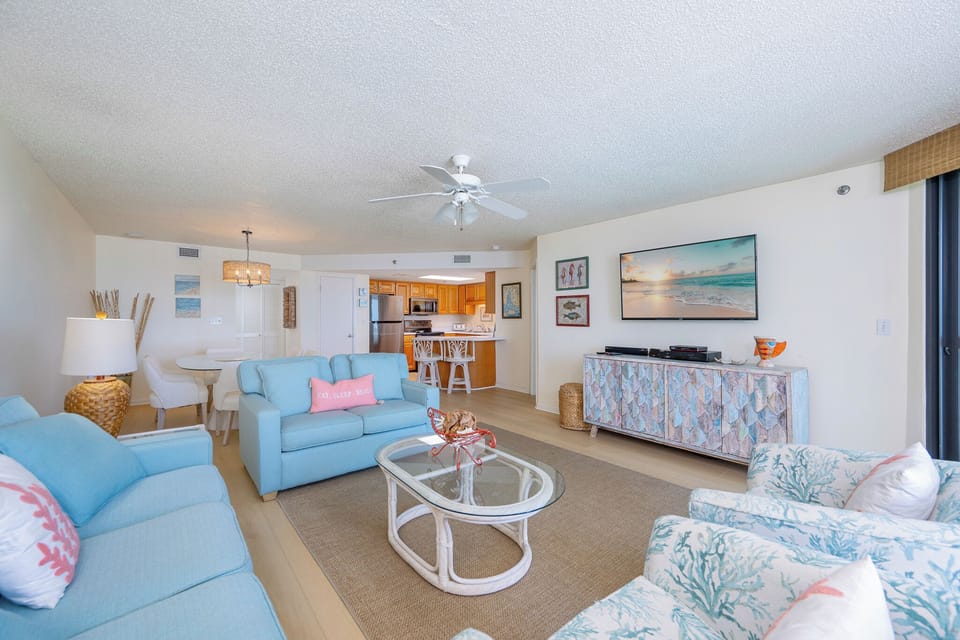 The living room invites you to sink into cozy seats while watching your favorite movie on the big screen TV